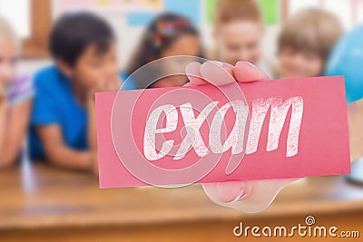 Exam against cute pupils and teacher smiling at camera in classroom Stock Photo