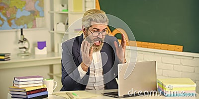 Exam results are complete surprise to him. Surprised teacher look at laptop. Bearded man express surprise. Pleasant Stock Photo