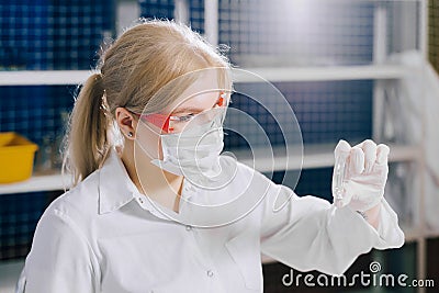 examining a tissue section for evidence of cancerous cells. a focused student-science works in a lab with a petri dish. Stock Photo