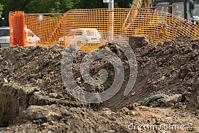 Excavated soil at construction site. Laying pipes in city. Excavated earth. Cable trench Stock Photo