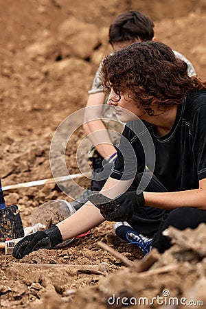 Excavations at the site of a war crime. Site of a mass shooting of people. Human remains bones of skeleton, skulls Editorial Stock Photo