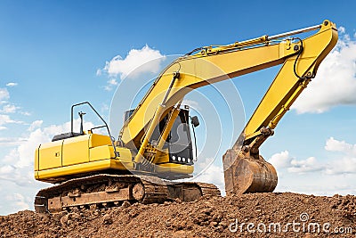 Excavator backhoe on the ground at construction site in blue sky background Stock Photo