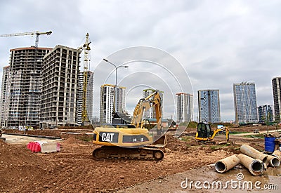 Excavator CATERPILLAR working at construction site. Construction machinery for excavation, loading, lifting and hauling of cargo Editorial Stock Photo