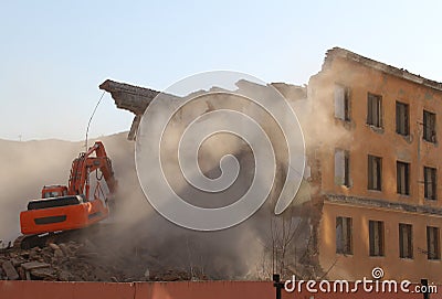 Excavator destroys old house. Stock Photo