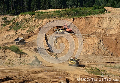 Excavator developing the sand on the opencast and loading it to the heavy dump truck. Processing of loose material in mining Editorial Stock Photo