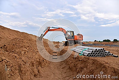 Excavator dig the trenches at a construction site. Trench for laying external sewer pipes. Sewage drainage system for a multi- Stock Photo