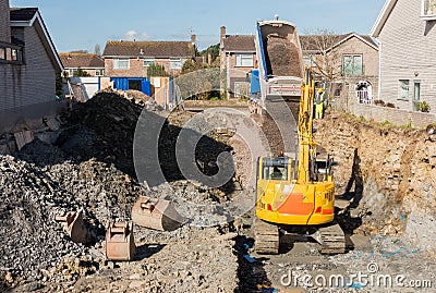 Excavator Digging while Dumper Truck is Unloading Stock Photo