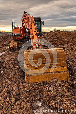 Excavator doing work on a wet and muddy winter day Stock Photo