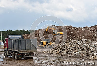 Excavator, dump truck and wheel loader at landfill for disposal of construction waste and concrete crushing. Recycling concrete Stock Photo