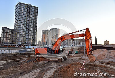 Excavator during excavation at construction site. Backhoe on road work. Heavy Construction Equipment Machines for Earthworks. Stock Photo