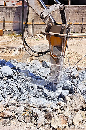 Excavator with hydraulic hammer breaking concrete Stock Photo