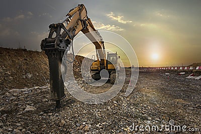 Excavator with hydraulic hammer on road construction works Stock Photo