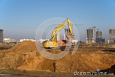 Excavator load the sand to the dump truck on construction site. Backhoe digs the ground for the foundation and construction Stock Photo