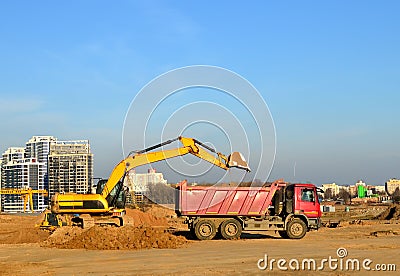 Excavator load the sand to the heavy dump truck on construction site. Excavators and dozers digs the ground for the foundation Stock Photo