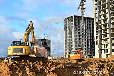 Excavator load the sand to the heavy dump truck on construction site. Excavators and dozers digs the ground for the foundation Stock Photo