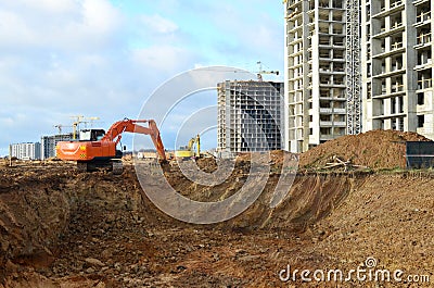 Excavator load the sand to the heavy dump truck on construction site. Excavators and dozers digs the ground for the foundation Stock Photo
