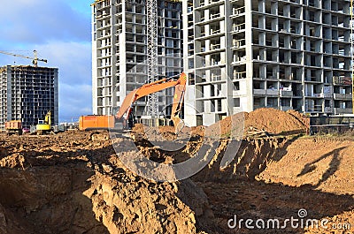 Excavator load the sand to the heavy dump truck on construction site. Excavators and dozers digs the ground for the foundation Stock Photo