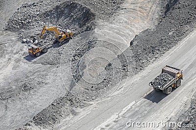 Excavator loads ore into a large mining dump truck. Top view Stock Photo