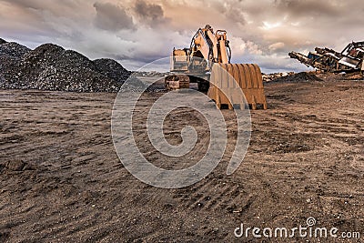 Excavator and machine to pulverize stone in a quarry Stock Photo