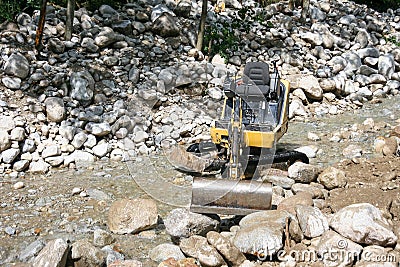 Excavator in the mountan stream river Stock Photo