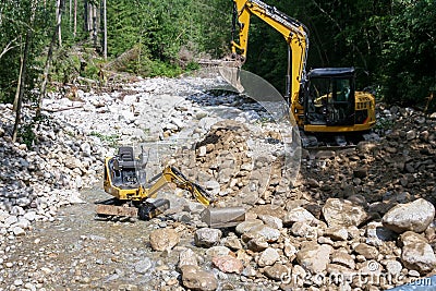 Excavator in the mountan stream river Stock Photo