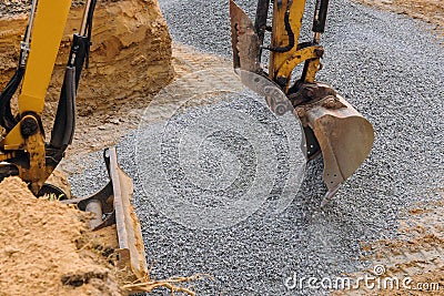 Excavator moving gravel in house under construction Stock Photo