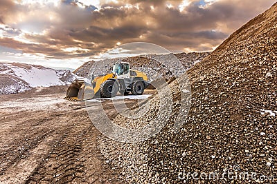 Excavator moving stone in an open pit mine in Spain Stock Photo