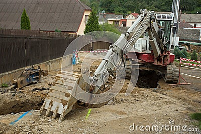 Excavator ploughshare on trench - constructing canalization Stock Photo