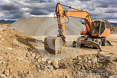 Excavator in a stone extraction mine to transform into a gravel Stock Photo