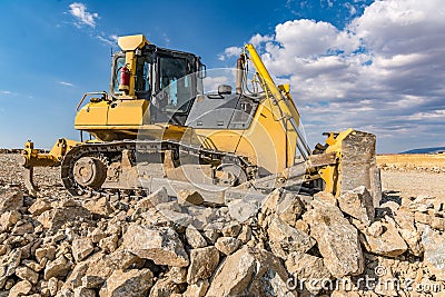 Excavator surrounded by granite rock to transform into gravel Stock Photo