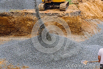 Excavator uploader moving gravel on of construction foundation Stock Photo