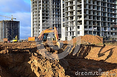 Excavators and dozers digs the ground for the foundation and construction of a new building. Stock Photo