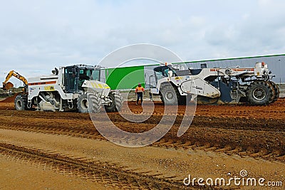 Excavators prepare terrain for parking place at industry building Editorial Stock Photo