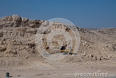 Excavators working in quarry breaking the rocks with mountains nearby Editorial Stock Photo