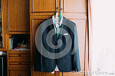 Excellent expensive black blazer hanging on wardrobe in hotel room interior Stock Photo