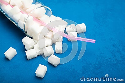 Excess sugar in a loose glass on a blue background, concept Stock Photo