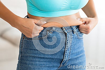 Unrecognizable Woman Touching Drooping Stomach After Weight Gain At Home Stock Photo