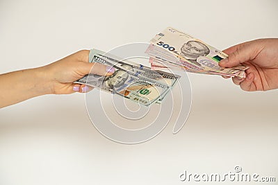 Exchange in the hands of 100 dollars for 500 and 200 hryvnias on a white background, give and take money, business Stock Photo