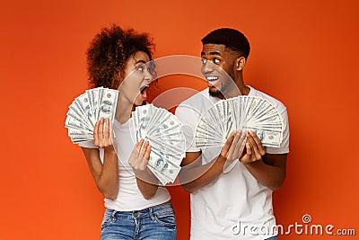 Excited african american couple holding bunch of money banknotes Stock Photo