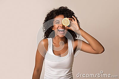 Excited african-american woman holding half of lemon Stock Photo