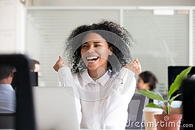 Excited African American woman receiving good news on laptop Stock Photo