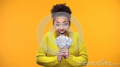 Excited Afro-American woman holding bunch of dollars, lottery winner, fortune Stock Photo