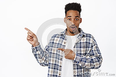 Excited and amazed african american guy, pointing fingers left at sale logo, showing banner, gasp in awe, staring Stock Photo