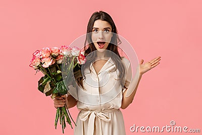Excited and amused, surprised gorgeous modern woman in trendy dress, spread hands sideways amazed and astonished, look Stock Photo