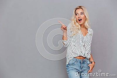 Excited attractive young woman pointing away Stock Photo