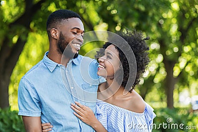 Excited black couple bonding while walking in park Stock Photo