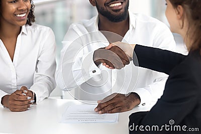 Excited black couple handshake female realtor closing deal Stock Photo