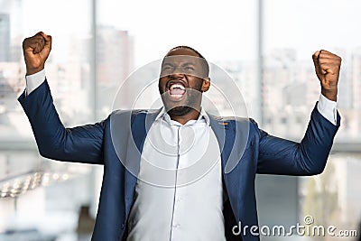 Excited black entrepreneur clenching his fists. Stock Photo