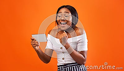 Excited Black Girl Holding Smartphone Gesturing Yes, Studio Shot Stock Photo