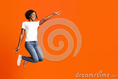Excited black woman jumping up and showing copy space Stock Photo
